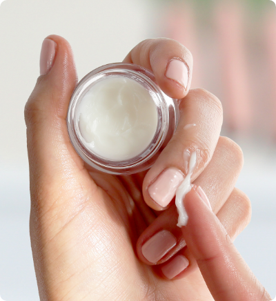 Hand putting Cuticle Balm on fingers